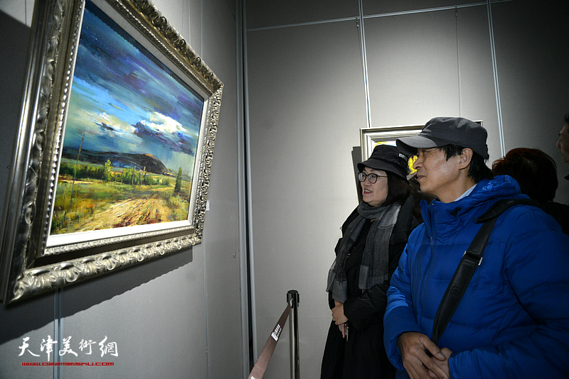 刘美然、崔亚正在画展现场观赏展出的作品。