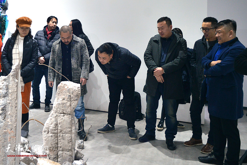 刘金凯与来宾在展览现场观看作品。
