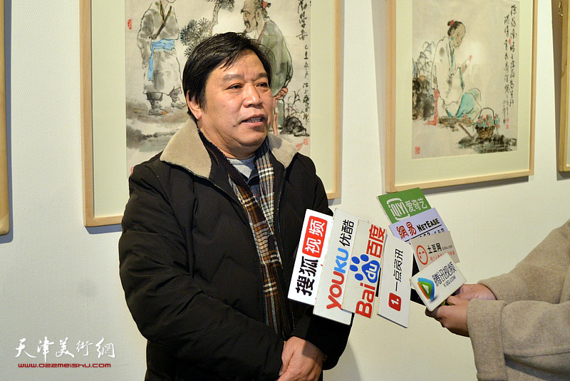 李耀春在画展现场接受媒体采访。