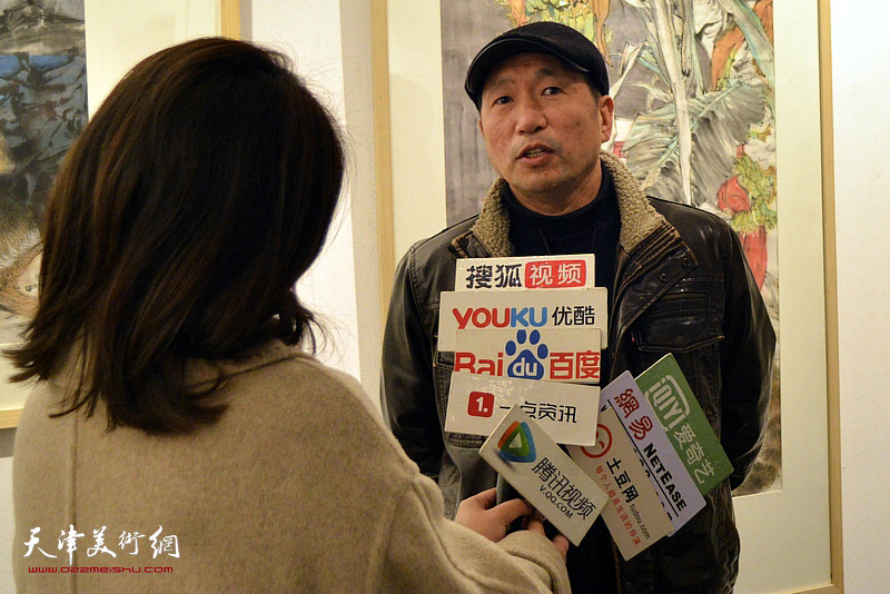 刘秋阳在画展现场接受媒体采访。