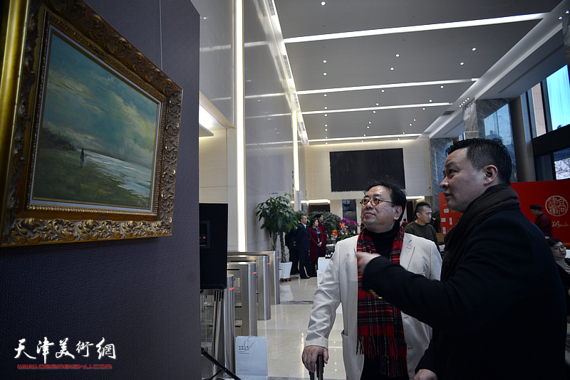高建章向观众介绍展出的油画作品。
