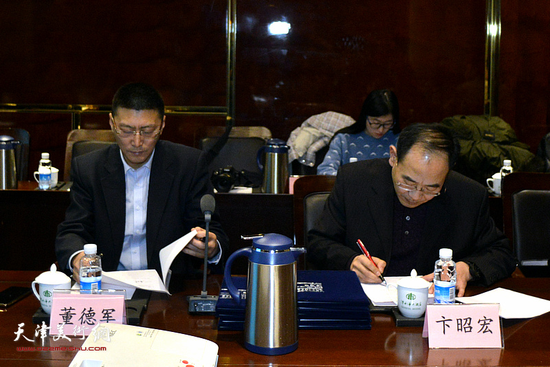 中华文化促进会传统委员会主任董德军与天津市商务经济研究会代表卞昭宏先生签订协议书。