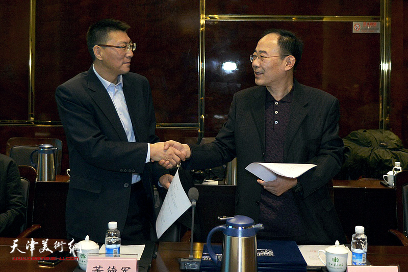 中华文化促进会传统委员会主任董德军与天津市商务经济研究会代表卞昭宏先生签订协议书。