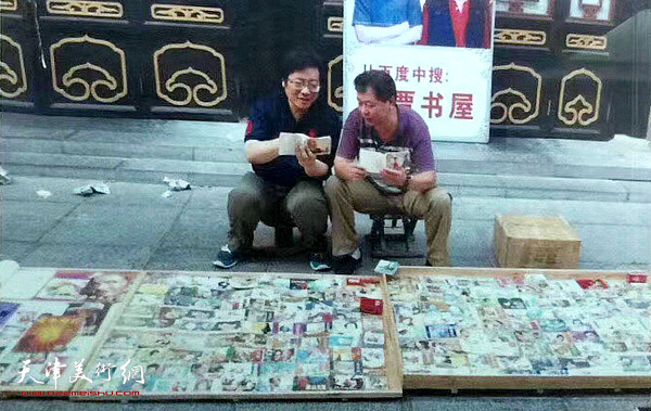贾世涛与媒体人、收藏家罗文华在观赏“小人书”。