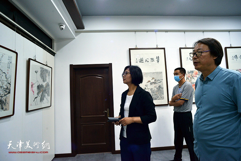 商芳颖、孔宪江在画展现场观看画作。