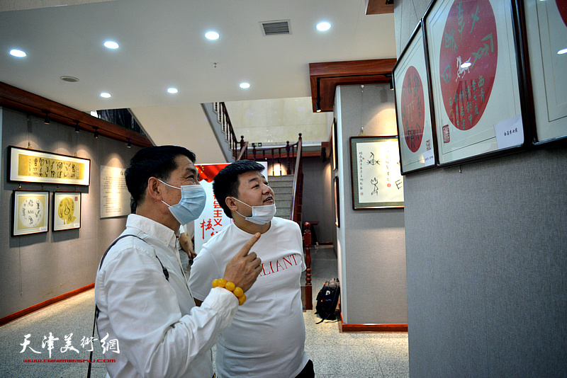 孟宪奎、孟庆海在展览现场观看作品。