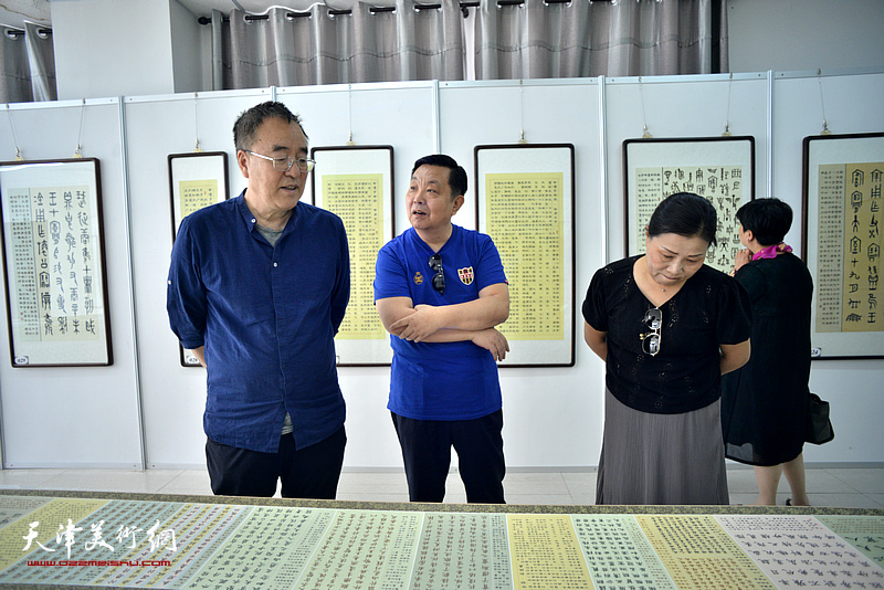马巍华向李治邦、刘静华介绍“汉字历史艺术馆”展出的作品。