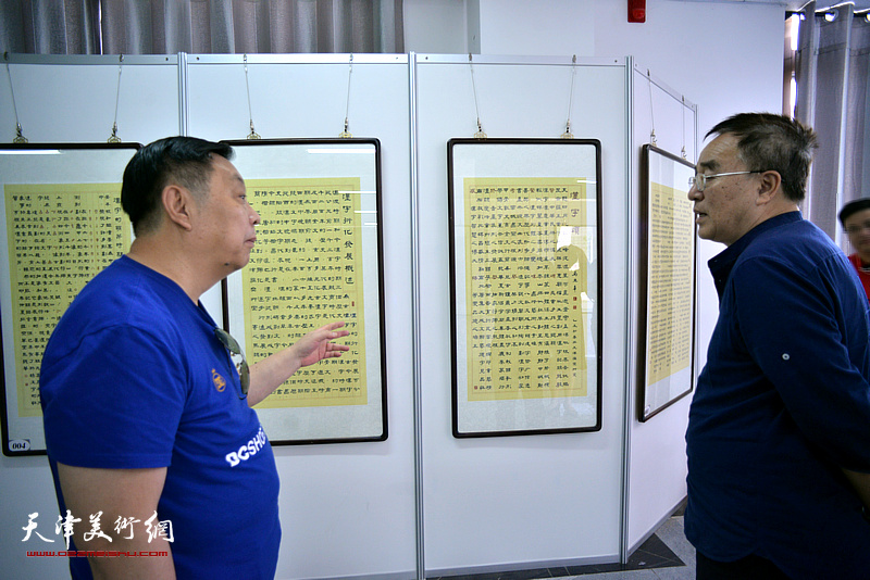马巍华向李治邦介绍“汉字历史艺术馆”展出的作品。