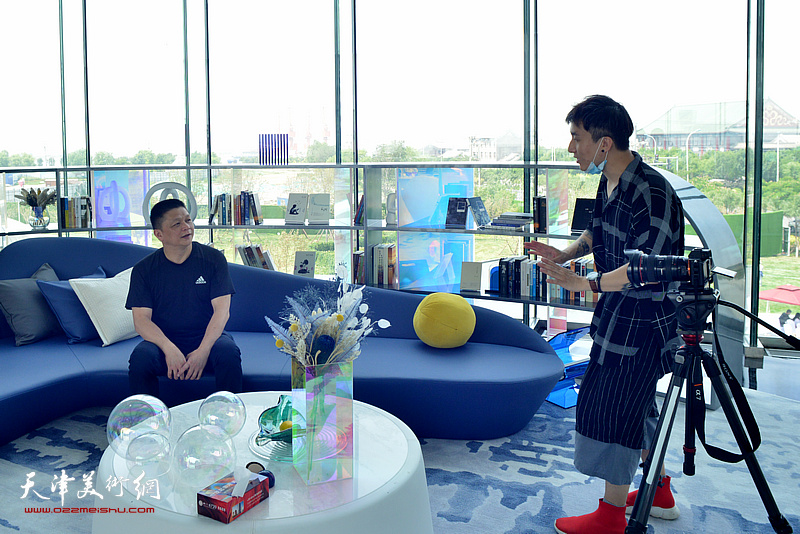 袁文彬在画展现场接受新媒体的采访。