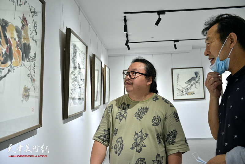 尹枫在公益展现场观看作品。