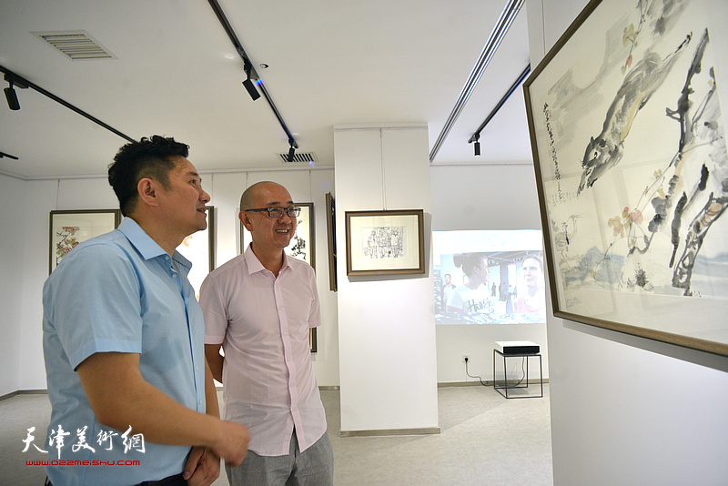 马驰、朱懿在观赏公益展展出的尹沧海作品。 