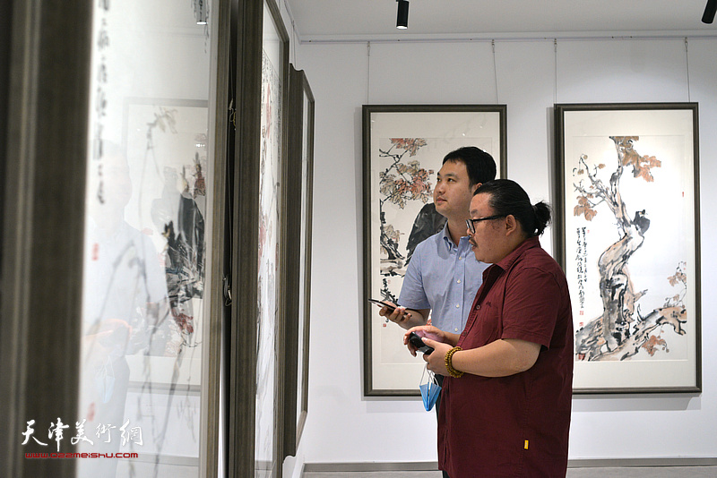 尹枫在观赏公益展展出的尹沧海作品。 