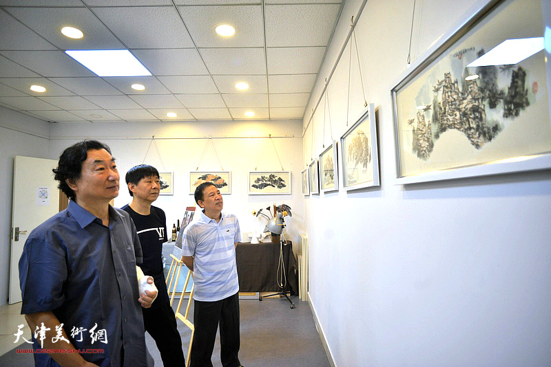 韩石、金石、王凤桐在三省斋观赏展出的扇面作品。