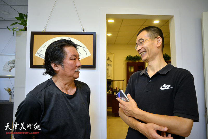 黄国华、姜金军在三省斋扇面作品展现场交流。