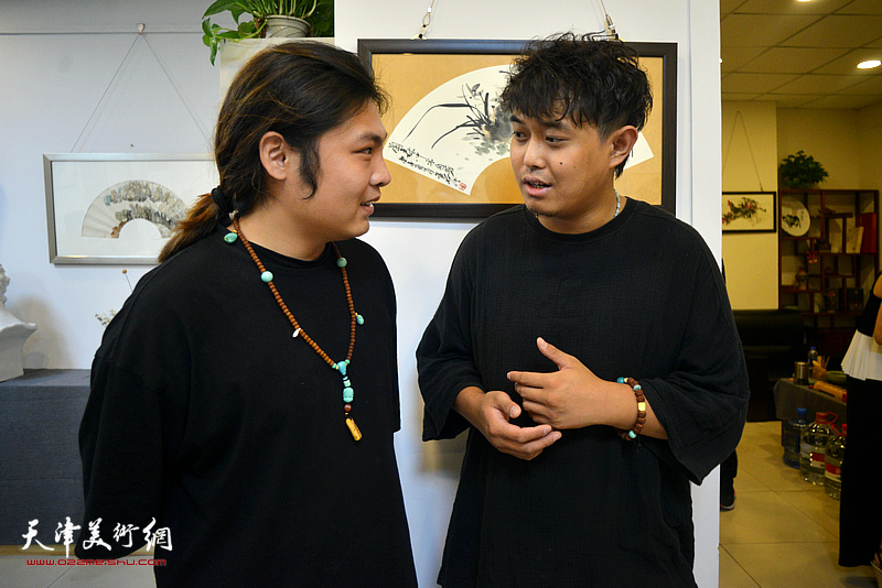 丁俊涵与来宾在三省斋扇面作品展现场交流。