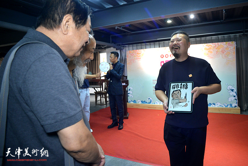 左川、刘栋在展览现场观看陈琛数字插画作品。