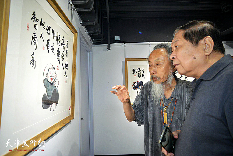 左川、刘栋观赏展出的作品。