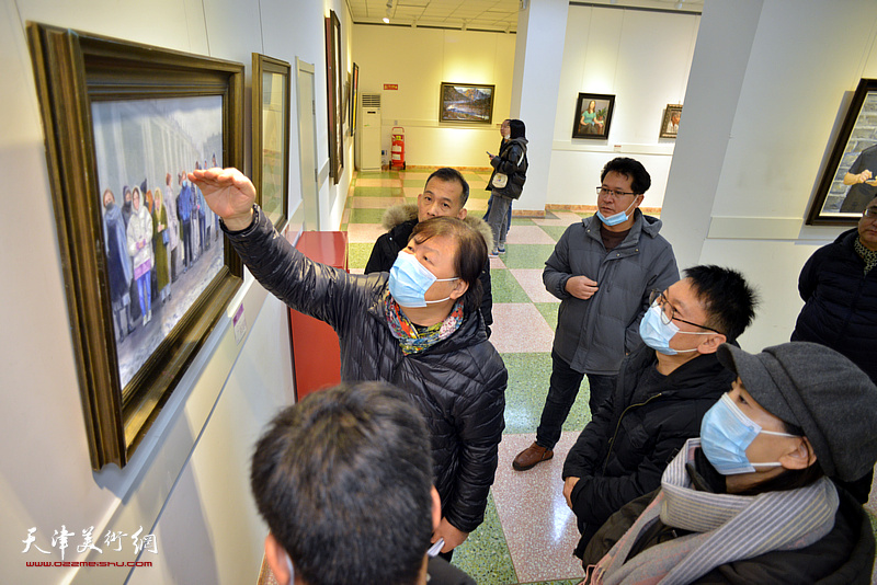 姜中立为参展画家点评展出的作品。