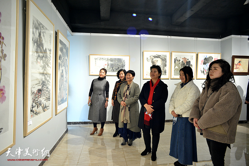 刘红与女画家王霞以及嘉宾观赏展出的作品。