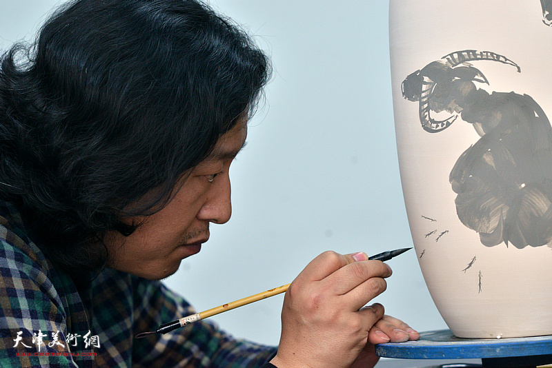 梁健在天津同飞书画院画青花瓷。