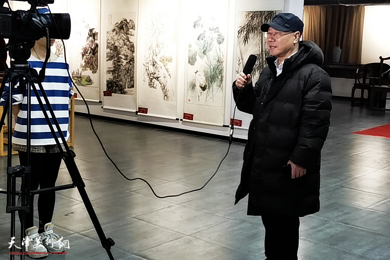 庞黎明在展览现场接受媒体采访。