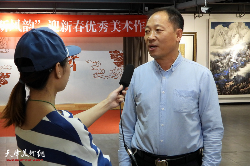 郑龙起在展览现场接受媒体采访。