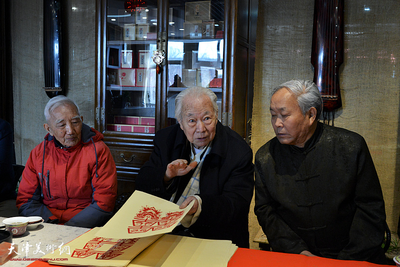 华非在书画名家惠民活动现场介绍收藏民间剪纸的体会。
