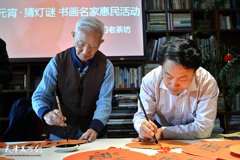 毕开文、刘俊坡在书画名家惠民活动现场挥毫。