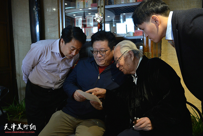 华非、罗文华、刘俊坡、华磊在书画名家惠民活动现场交流。
