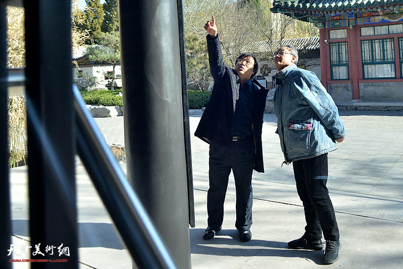 陈福春与冯钢在天津铁路文化宫观赏作品。