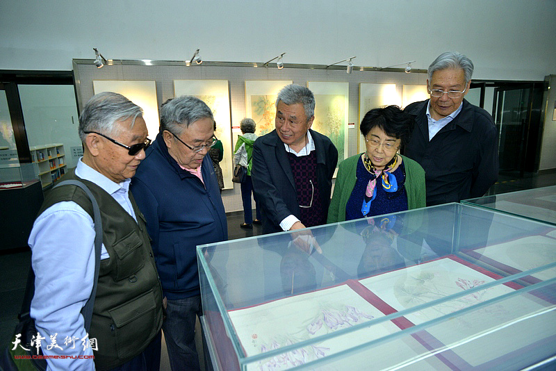 王建涛向李润兰、张云鹏介绍展出的画作。
