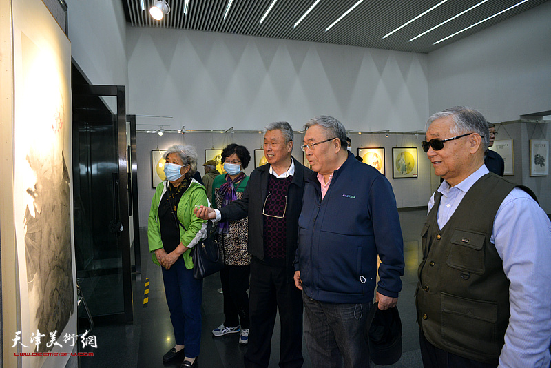 王建涛陪同左明等观赏展出的作品。