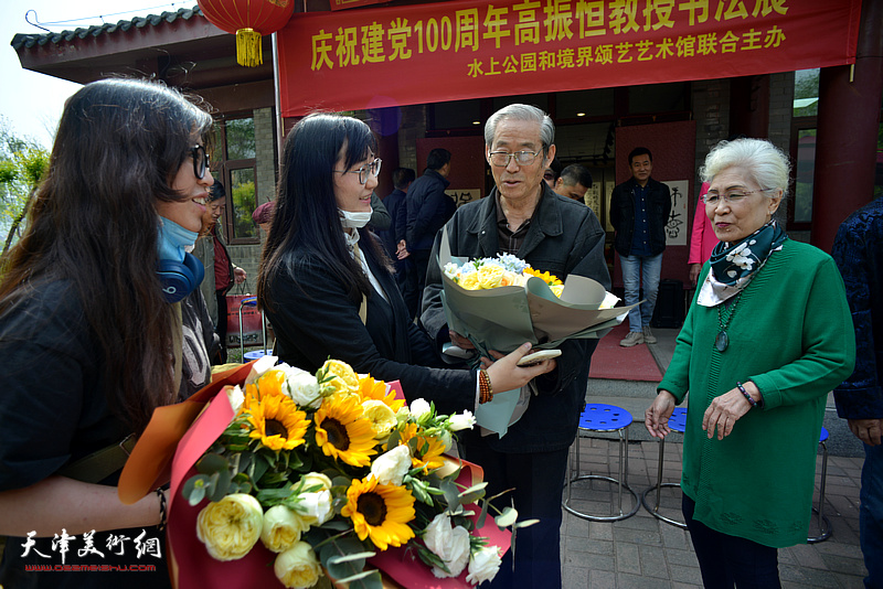 学生送上鲜花祝贺高振恒教授书法展开幕。