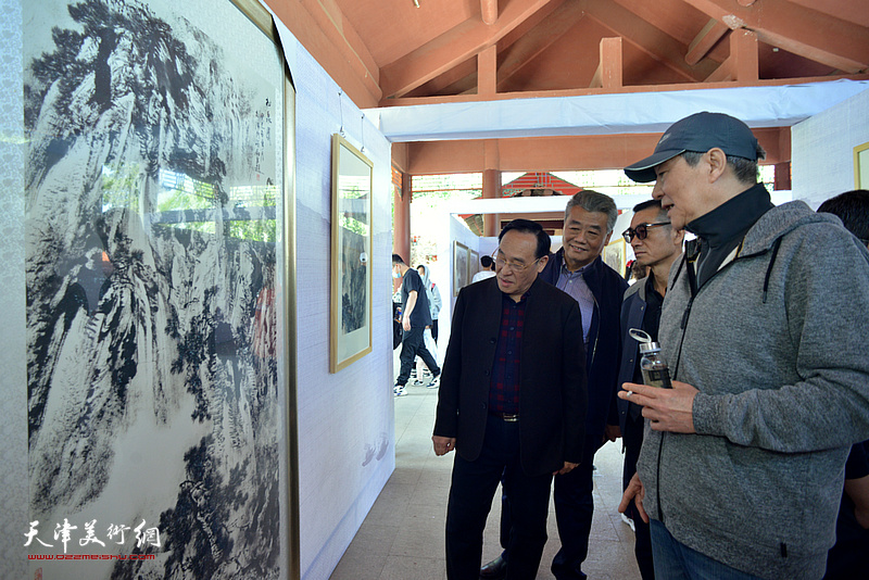 陈钢向张亚光、董其克、王维泉介绍展出的作品。