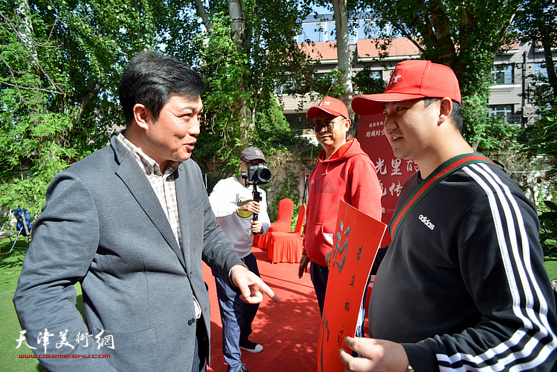 吕铁元为积极参与“跨越时空 红动四方”主题活动的热心游客赠送书画作品。