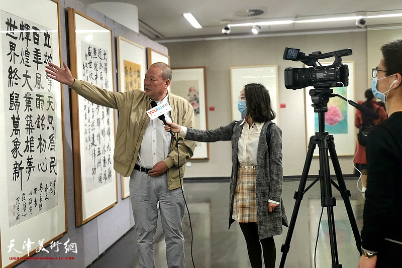 书法家马孟杰在中国美术名家邀请展现场向媒体介绍自己的作品。