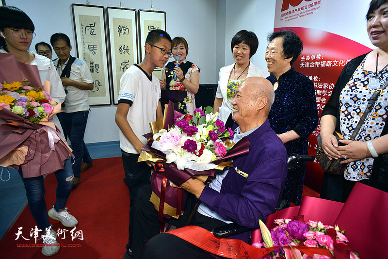 家人向韩征尘先生送上鲜花，祝贺画展圆满举行。