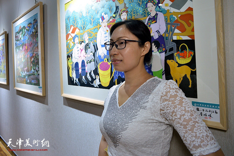 参展画家刘媛媛在展出的作品前。