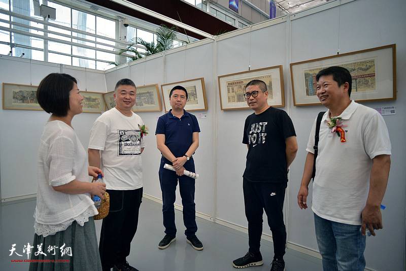 左起：窦士萍、窦洪伟、何纯、姜立志、魏瑞江在展览现场交流。