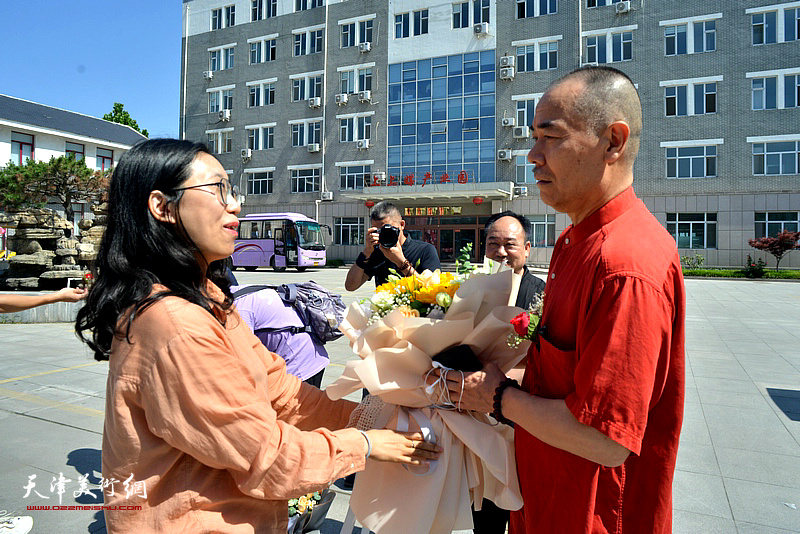 王慧智在山东的弟子为恩师献花，祝贺三见山水书画院首届院展开幕。