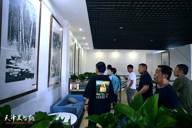 陈学文、郑永盛、皮志刚、李胜利在画展现场观看展出的作品。