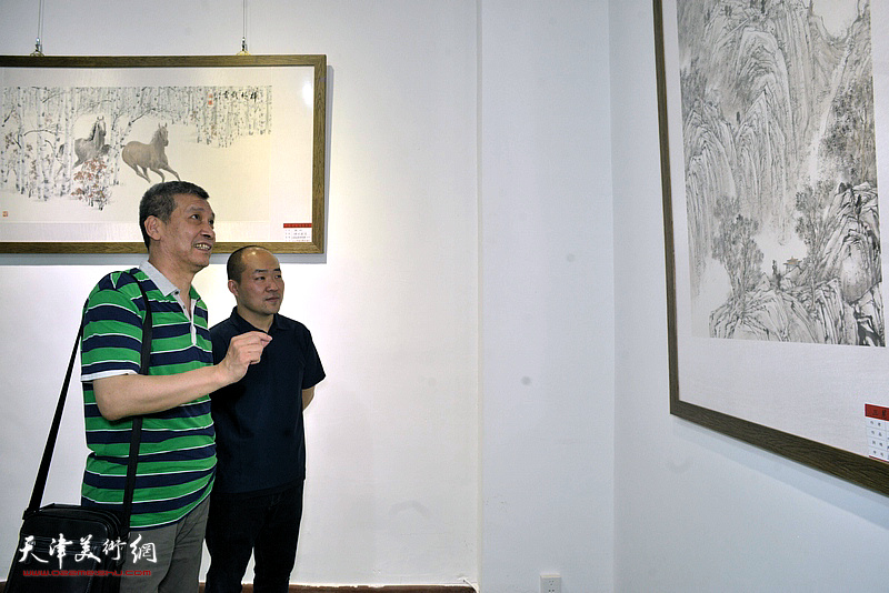 张涌、朱立鸿在画展现场观看展出的作品。