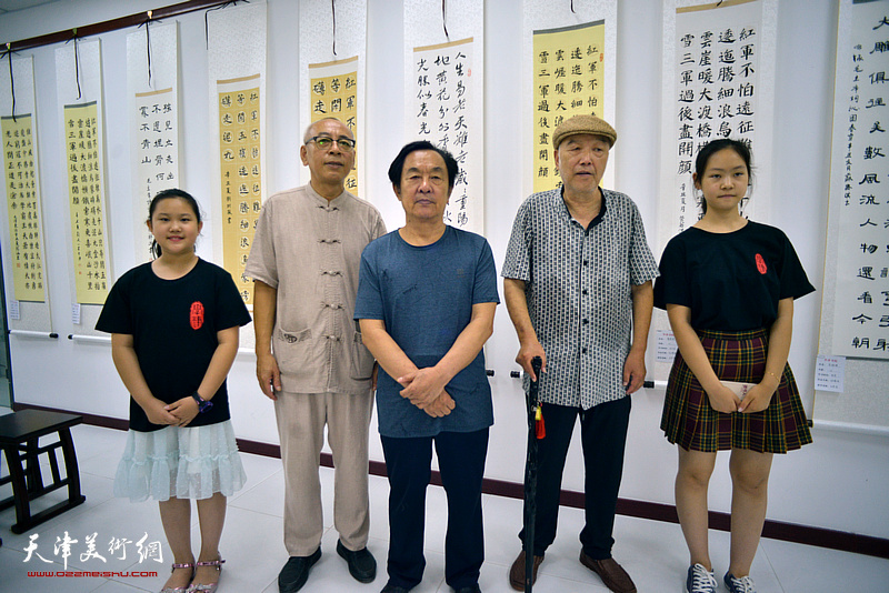 王全聚、顾志新、王炳学与优秀学员代表王涵艺、张露影在“师生同书毛主席诗词展”作品。