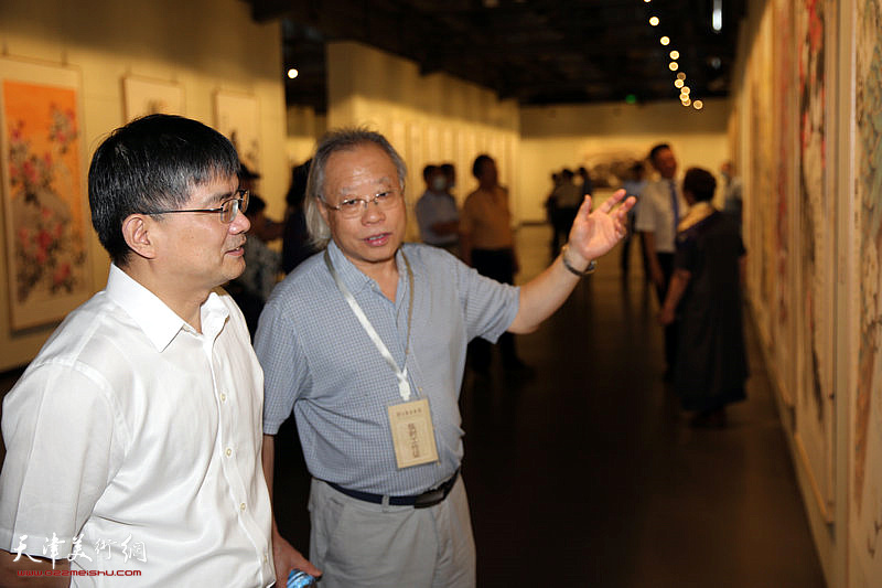 王金厚向郁标介绍展出的作品。