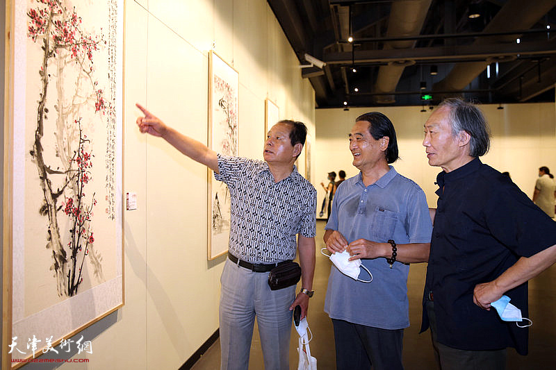 刘士忠、刘荣生、王佩翔观赏展出的作品。