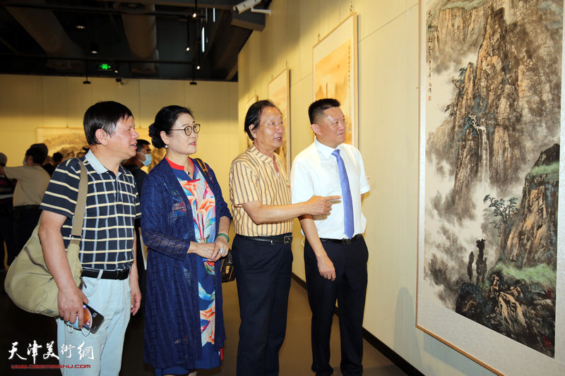 张爱国、刘家城、王俊英、李根友观赏展出的作品。