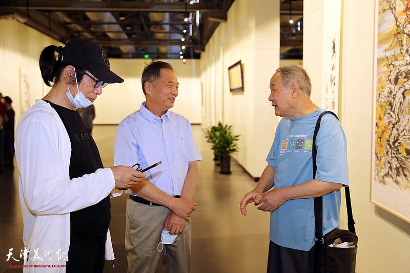 张葆东、邢立宏、张晋在画展现场交流。