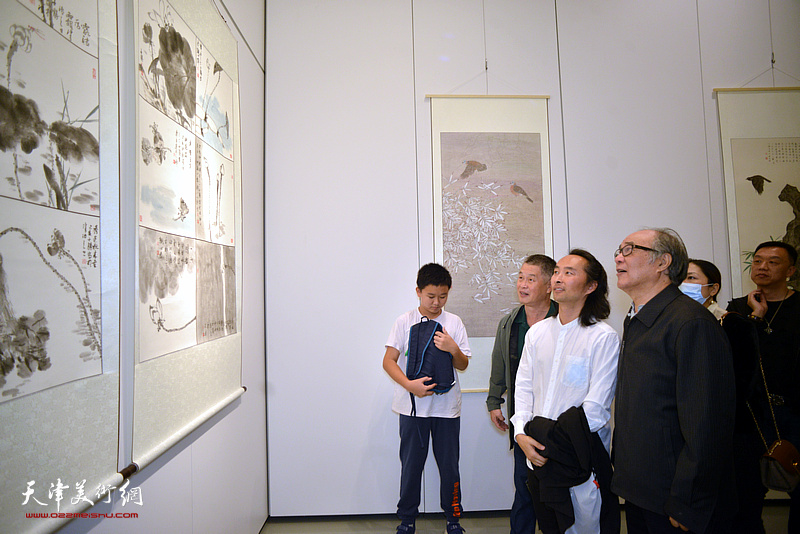 郭书仁与学生安士胜、曹立观赏展出的作品。