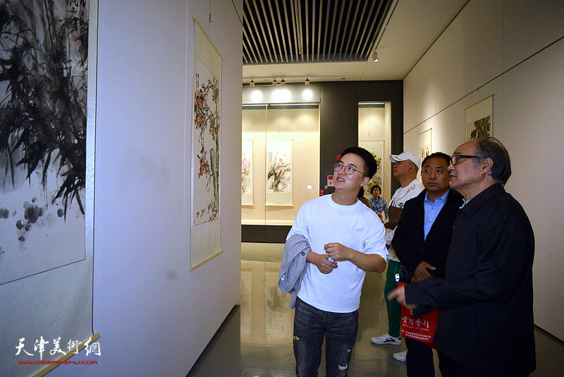 郭书仁与学生齐昊、袁树茂观赏展出的作品。