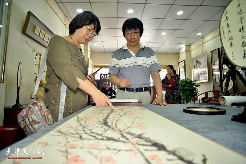 刘新尧、张蕙玲观赏展出的孟宪义作品。